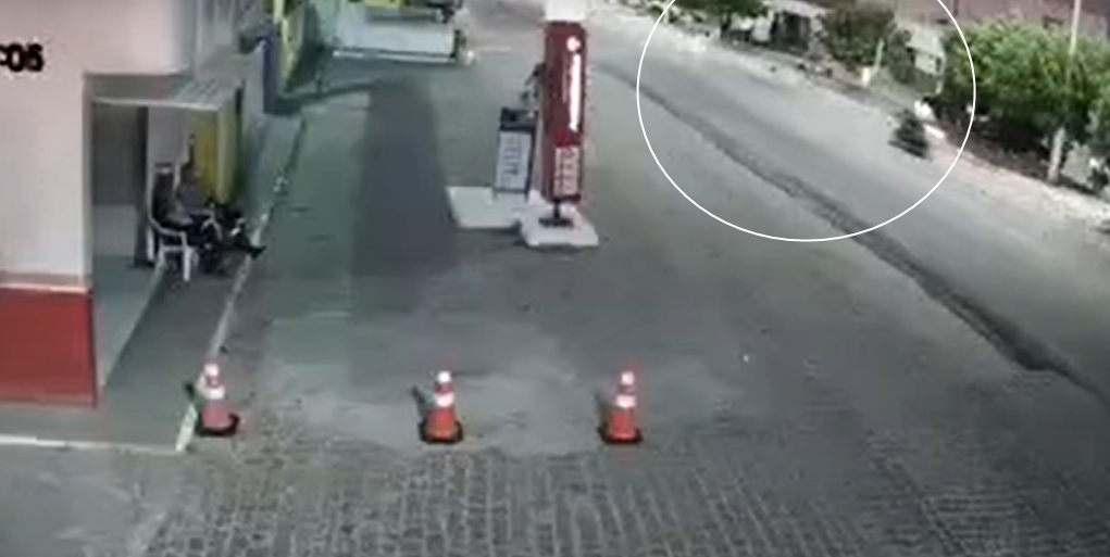 O circulo mostra a moto em direção à idosa que atravessa a pista. (Foto: Reprodução/Câmera de Segurança)